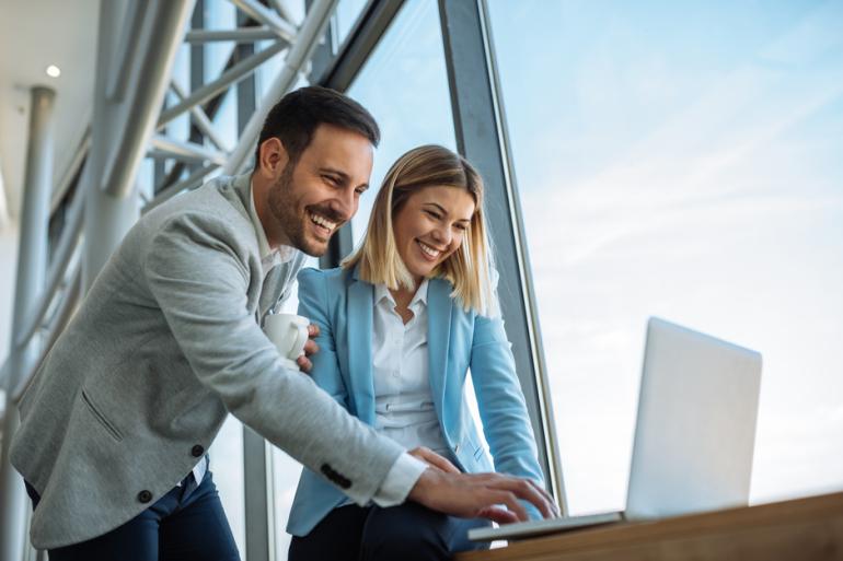 Hombre y mujer revisando información en un computador